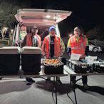 Volunteers behind tabes, in front of the van