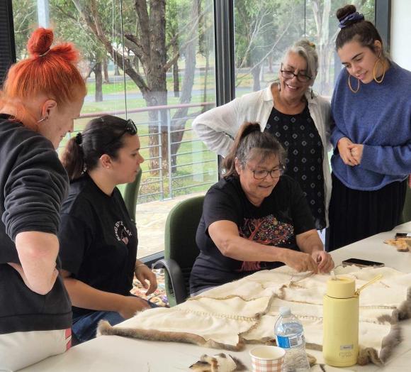Women working to create a cloak