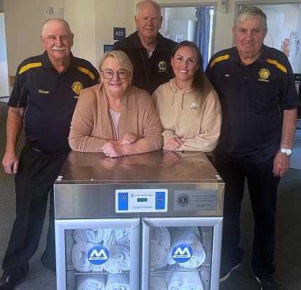 Lions and family standing behind the blanket warmer