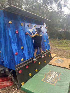 Young scout on portable bouldering wall