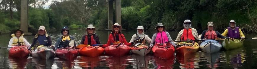 Paddlers in Kayaks lined up across the river